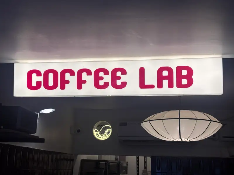 The warm lantern and red lettering of Coffee Lab